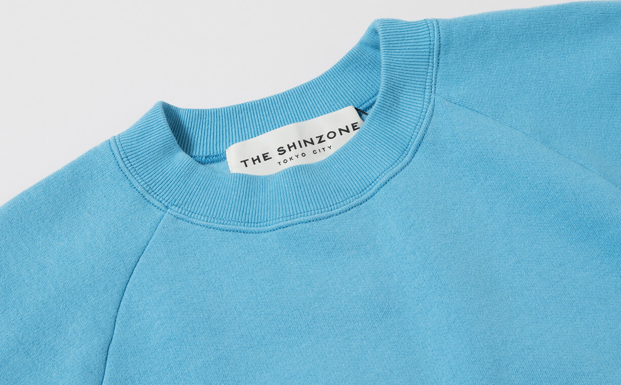 ザシンゾーンのパステルブルーのスウェットシャツの襟元のアップ