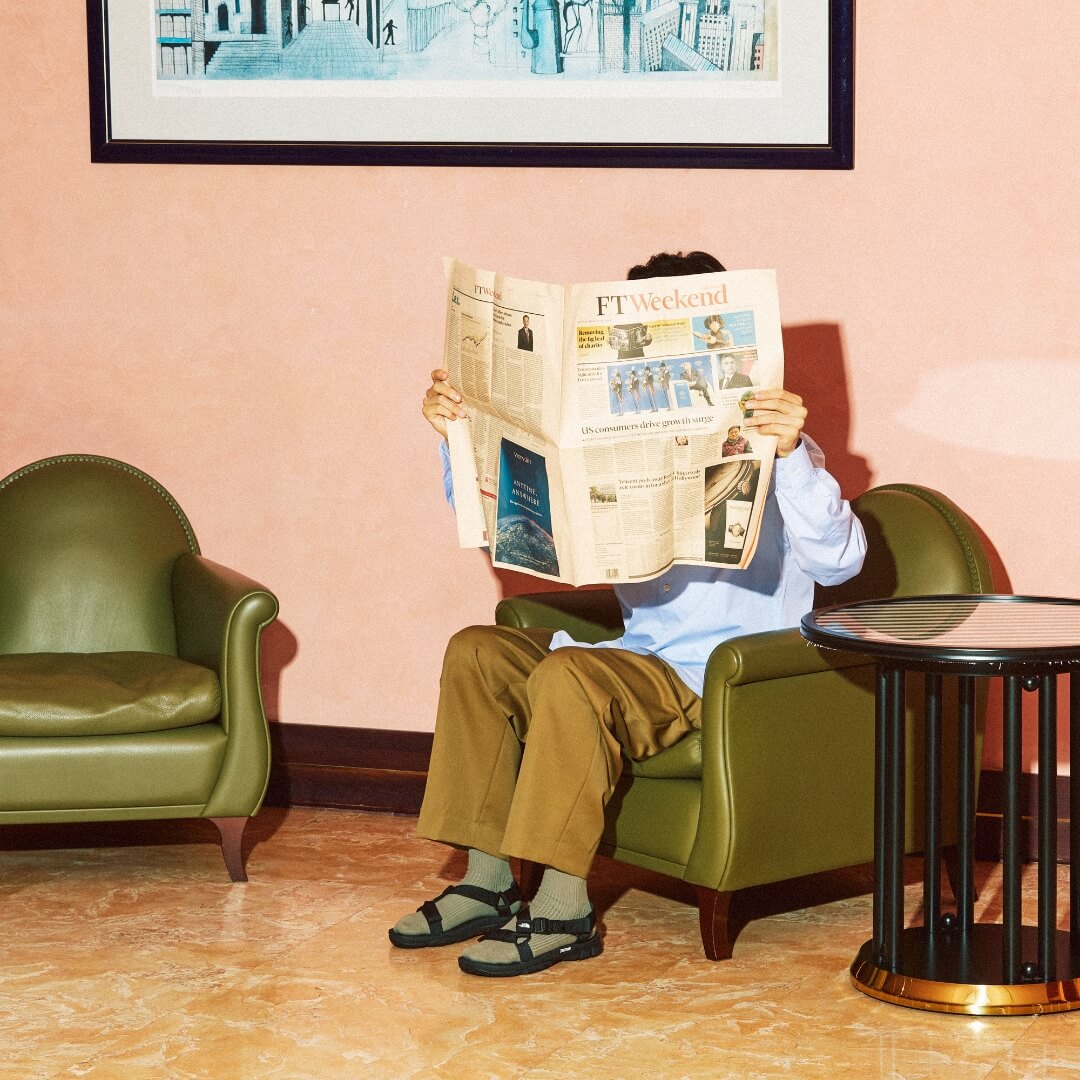 ULTRA STARTUM PROを履き新聞を読む男性
